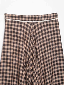 Detail of high waist plaid skirt with delicate white lace trim on the fabric seam