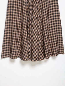 Close-up of brown and black gingham check fabric with natural ruffle texture and folds