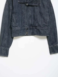 Detail of vintage grey washed denim jacket with unique wavy texture and metal buttons