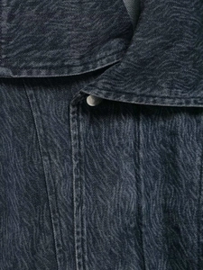Detailed macro view of retro textured denim jacket fabric with vintage spiral wash patterns