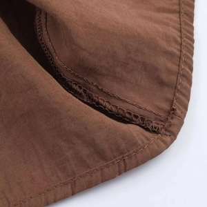 Detail shot of brown fabric texture showing fine stitching and inner seam craftsmanship