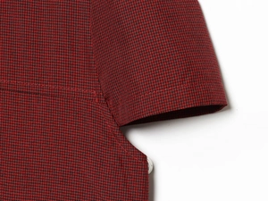 Détail du tissu à motif à carreaux rouge et noir et couture de qualité sur manches courtes