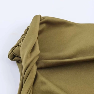 Detailed close-up of olive green ruched fabric and twisted seam texture on this slim dress