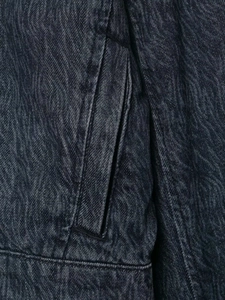 Detail of dark grey washed denim fabric texture and pocket stitching on retro jacket