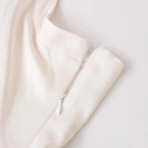Close-up of cream white halter dress with high-quality twill fabric and hidden zipper detail
