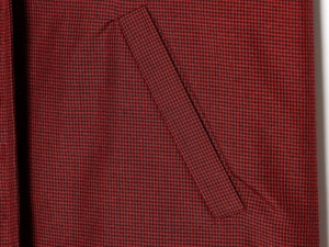 Vue détaillée de la chemise à motif pied-de-poule rouge et noir avec poche latérale oblique