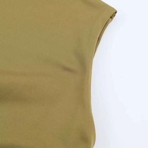 Close-up detail of mustard green knitted fabric texture and seamless shoulder stitching