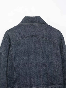 Detail of vintage grey denim jacket showing textured twill fabric and neat stitching