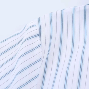 Détail des coutures d'épaule sur une robe chemise à rayures bleues et blanches en coton