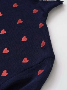 Detailed macro view of heart embroidery on dark blue knit top with mesh splicing