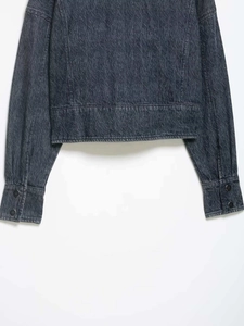 Detailed view of dark grey denim jacket with vintage texture and double-button cuffs