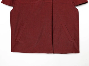 Détail de veste pied-de-poule bordeaux avec poches latérales obliques symétriques et rabat
