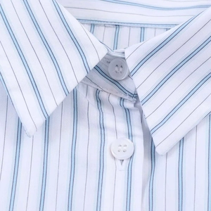 Détail du col de chemise à rayures bleues et blanches avec boutons et coutures fines