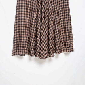 Plaid midi skirt with black and brown checks featuring ruffle details and pleated hem