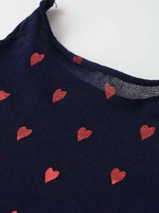 Close-up of navy knit fabric with red heart embroidery and fine texture details