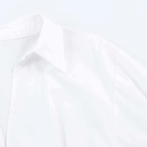 Close-up of a white V-neck shirt dress showing neat collar cut and smooth fabric texture