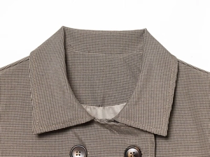 Détail du revers et des boutons ambrés sur une veste de costume à motif pied-de-poule