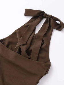Detail des eleganten karamellbraunen Neckholder-Kleids mit großer Schleife am Rücken