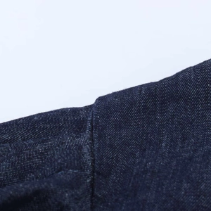 Detailed close-up showing the shoulder seam and stitching of a dark blue denim mini dress