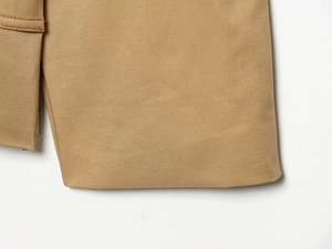 Dettaglio del tessuto twill kaki con cuciture precise su questo trench corto