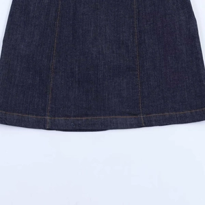 Close-up of deep blue denim dress hem with yellow contrast stitching and twill texture
