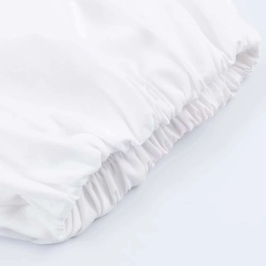 Detailed macro view of white puff sleeve cuff with elastic smocking and fine stitching