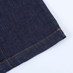 Detailed close-up of navy blue denim dress hem with contrast orange stitching and twill texture