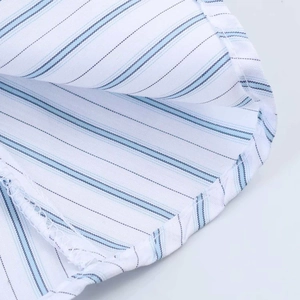 Gros plan sur le tissu en coton à rayures bleues avec coutures fines et texture lignée