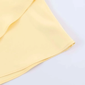 Detail of light yellow satin halter top showing fine single needle hem stitching