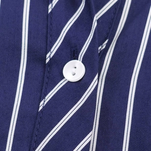 Close-up of navy blue striped shirt fabric with white round button and neat stitching