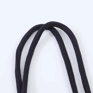 Dettaglio delle sottili spalline nere e della trama in maglia di un body elastico