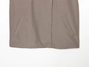 Détail de la veste en laine à carreaux avec poches avant inclinées symétriques