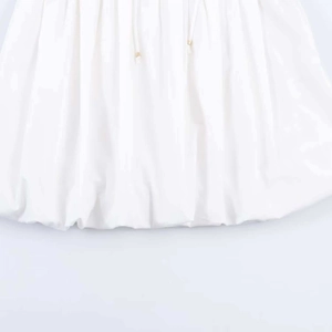 Detail of white bubble hem skirt showing drawstring with golden metal tips