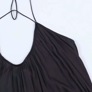 Detail of black satin halter neckline with delicate pleated design and slim straps