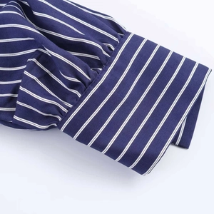 Detailed close-up of navy blue striped shirt cuff with elegant pleats and puff sleeve design