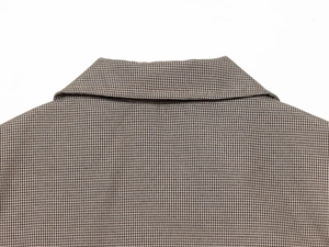 Détail du col d'une chemise à carreaux marron et noir avec des coutures de haute qualité