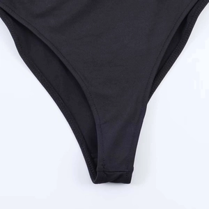 Dettaglio del body nero con texture in maglia elastica e cuciture sul giro gamba