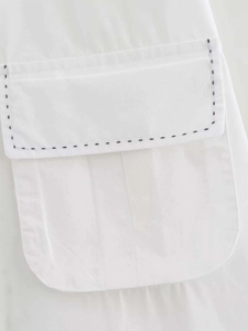 Nahaufnahme der Hemdtasche in Weiß mit dekorativen schwarzen handgenähten Nähten als Detail