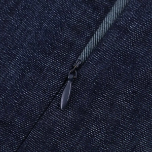 Macro detail of high-quality dark blue denim fabric and hidden invisible zipper closure