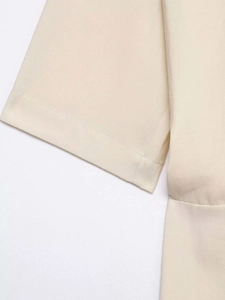Detail view of stitched ruffle sleeve on apricot summer dress featuring woven fabric texture