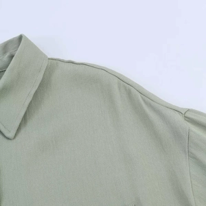 Close-up of a light green twill shirt showing the lapel collar and fine stitching detail