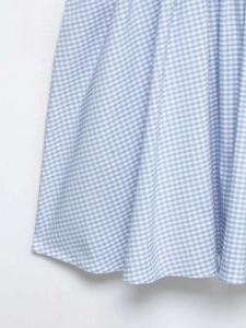 Détail du tissu à carreaux vichy bleu clair et blanc montrant la texture d'une robe