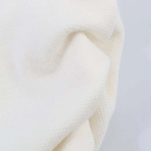 Gros plan sur la maille blanche avec plis doux et détails élégants en dentelle fine