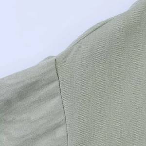Detail of light green twill fabric showing precise stitching and smooth texture