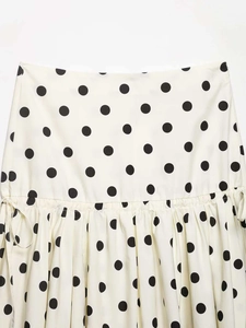 Detailed view of cream polka dot skirt with adjustable side drawstrings and ruching