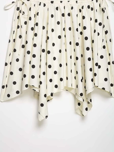 Detail of polka dot midi skirt featuring asymmetric handkerchief hem and side drawstrings