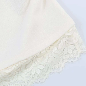 Détail de l'ourlet en tricot blanc avec bordure en dentelle florale délicate