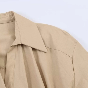 Gros plan d'une robe kaki montrant le col pointu et la texture du tissu en coton