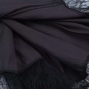 Close-up of black satin fabric with intricate lace trim detail on a backless dress
