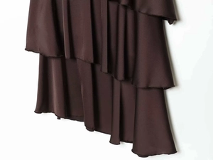 Detailed view of layered satin skirt hem with elegant ruffles in deep chocolate brown